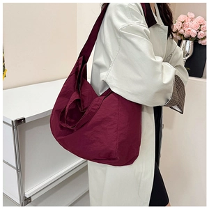 Close-up of a burgundy canvas tote bag with textured fabric and durable zipper detail