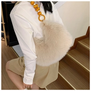 Détail du sac à main en peluche avec bandoulière en perles ambre et texture douce en fourrure