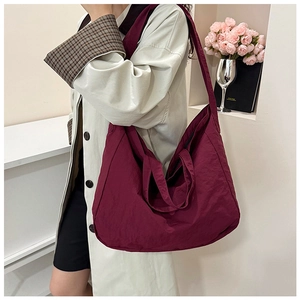 Detail of burgundy large nylon tote bag showing soft texture and spacious design on a model