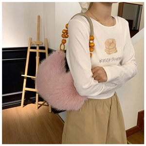 Détail du sac croissant en peluche rose avec bandoulière unique en perles de bois
