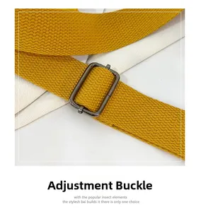 Detail view of yellow nylon strap with adjustable gunmetal buckle for shoulder bag