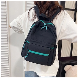 Close-up of lightweight black casual backpack with vibrant teal zipper detail for women