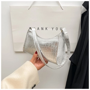 Detailed close-up of metallic silver hobo bag with embossed crocodile texture