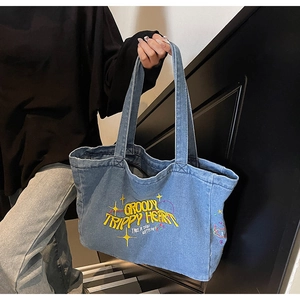 Détail du sac cabas en denim bleu avec broderie jaune Groovy Trippy Heart et bretelles