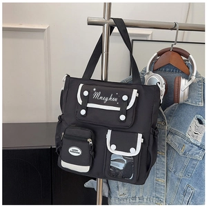 Detail of black multi-pocket functional tote bag with white trim and magnetic buckles