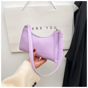 Detail of lavender crescent bag featuring faux crocodile texture and gold zipper