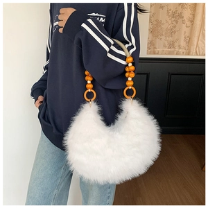 Détail du sac croissant en peluche blanche avec poignée perlée orange et fausse fourrure