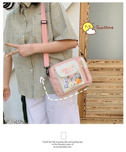 Détail du sac bandoulière en toile rose avec fenêtre transparente et breloques lapin