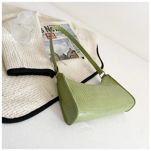 Close-up of light green crocodile pattern handbag with elegant half-moon shape