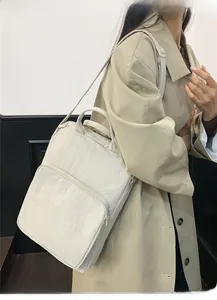 Dettaglio della borsa capiente in nylon indossata da una modella in stile urbano moderno