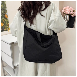 Modern minimalist large capacity black tote bag styled in a casual home living scene