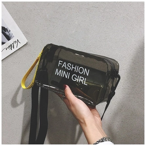 Bolso silla de gelatina gris humo translúcido con correa negra y detalle amarillo