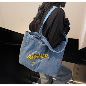 Photo style urbain d'un grand sac cabas en denim délavé bleu clair avec broderie rétro
