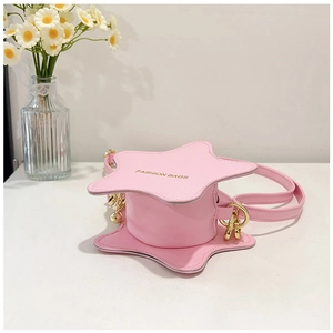 Detail of star-shaped pink leather bag featuring gold lettering and metal bell charm