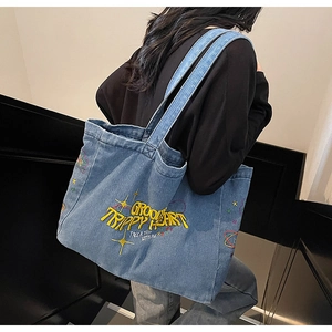Détail du sac cabas en toile délavée bleue avec broderie jaune et grande capacité