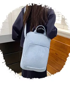 Dettaglio della borsa in nylon azzurro con tracolla e materiale dalla trama stropicciata