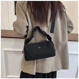Rear view of a model wearing a black nylon shoulder bag with cloud-like ruched handle
