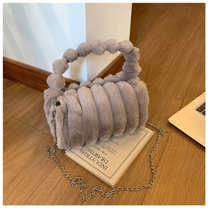 Détail de la texture d'un sac à main gris en peluche avec chaîne en métal argenté