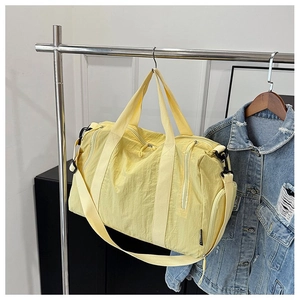 Close-up of yellow large-capacity nylon fitness bag with zipper and woven label detail