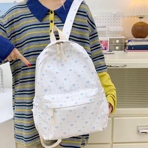 White casual backpack with blue heart patterns and braided zipper pulls for students