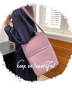 Dettaglio della borsa tote in nylon viola con tasca a zip portata a spalla