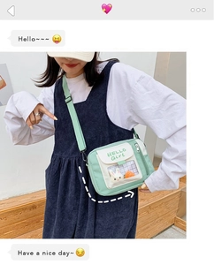 Gros plan détaillé d'un sac bandoulière en toile verte avec des lapins dans une poche transparente