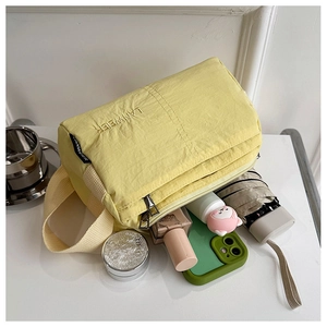 Detailed view of yellow nylon crossbody bag storage capacity with daily essentials