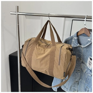 Close-up of khaki nylon gym bag featuring reinforced handles and adjustable shoulder strap
