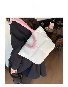 Close-up of white quilted tote bag with pink straps shown in a cozy cafe setting
