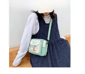 Détail du sac bandoulière en toile vert menthe avec fenêtre transparente et lapin