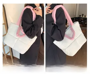Detail showing the white quilted puffer tote bag with vibrant pink shoulder straps