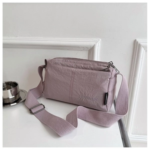 Minimalist lilac nylon crossbody bag with multi-zipper compartments and adjustable strap