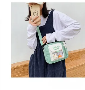 Détail du sac en toile vert menthe avec fenêtre PVC et décor lapin porté par un mannequin