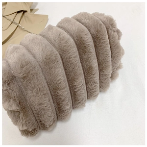 Détail du sac polochon en fausse fourrure taupe avec plis verticaux et chaîne en métal