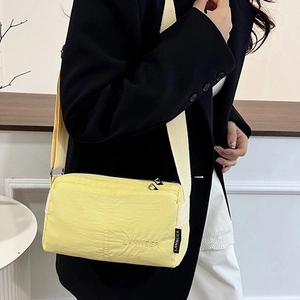 Minimalist light yellow nylon crossbody bag with multiple zippers and wide strap
