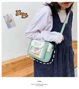 Détail du sac à bandoulière vert menthe avec poche transparente en PVC et peluche de lapin