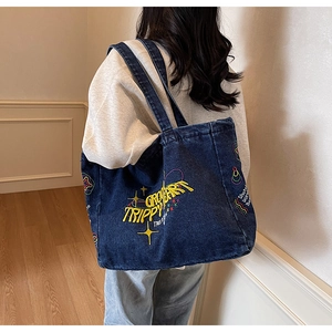 Vue détaillée du cabas en denim bleu foncé avec broderie jaune Trippy Heart et bandoulière
