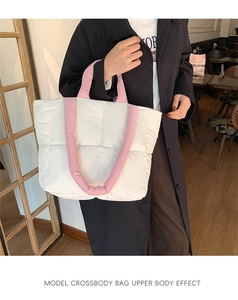 Quilted tote bag with pink padded handles shown on model in a modern indoor setting
