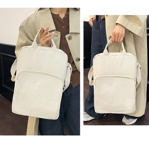 Dettaglio della borsa in tessuto Oxford bianco con tracolla regolabile e tasca a zip