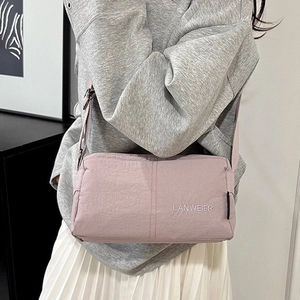 Pink nylon crossbody bag with vertical stitching and adjustable shoulder strap for women