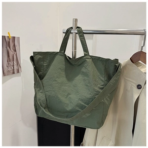Detail view of olive green canvas tote bag showing lightweight nylon fabric texture and handles