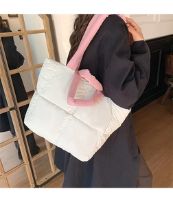 Detailed shot of white quilted puffer tote bag featuring pink contrasting shoulder straps