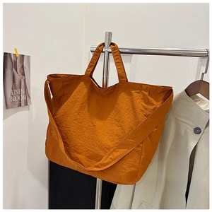 Detail view of large orange canvas tote bag with adjustable wide shoulder strap