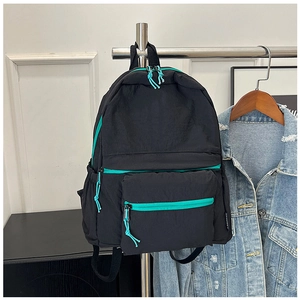 Detail of nylon travel backpack with teal zipper trim and large storage pockets