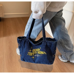 Détail du sac cabas en denim bleu avec broderie rétro jaune et design esthétique vintage