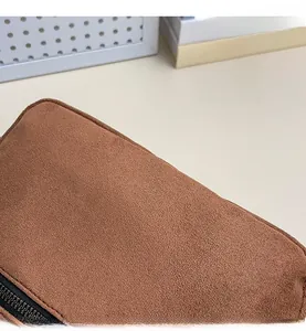 Detail of brown faux suede texture and precise stitching on the minimalist crossbody bag