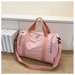 Detail view of pink large capacity nylon travel bag with handles and adjustable strap