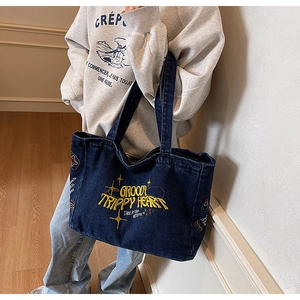Détail de la broderie Groovy Trippy Heart jaune sur un sac cabas en denim bleu