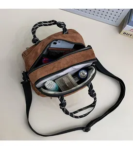 Detailed interior of brown suede crossbody bag showing large storage capacity and items