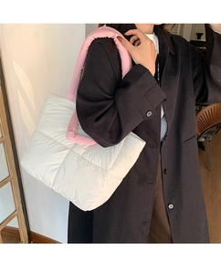 Quilted puffer tote bag in white with pink handles shown on a model for daily commute